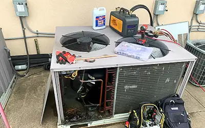 A customer's outside HVAC unit with our bag of tools.