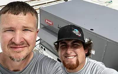 Owner Matthew Phillips and a technician, taking a break from fixing an air conditioner.